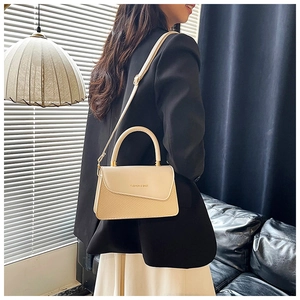 Detail of beige shoulder bag with chic woven texture and asymmetrical flap design