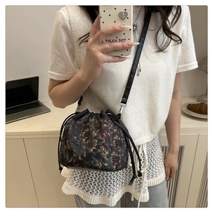 Close-up of vintage floral print bucket bag with drawstring closure and slim shoulder strap
