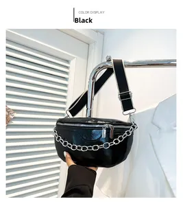 Detail view of black high-gloss waist bag with silver chain and dual zipper design