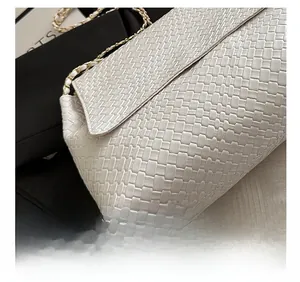Gros plan sur le cuir tressé blanc et la chaîne dorée de ce sac bandoulière
