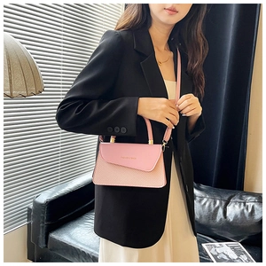 Close-up of pink woven and leather patchwork small square bag with metal clasp and strap