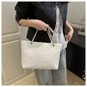 Close-up of white woven plaid tote bag featuring high-quality texture and chain strap detail