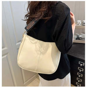 Detail of off-white faux leather shoulder bag with vintage geometric embroidered strap
