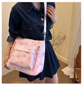 Pink floral tote bag featuring rose patterns and a bow detail worn by a model