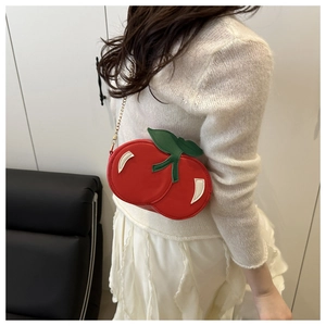 Detailed close-up of cherry-shaped shoulder bag with red PU leather and green leaf accent