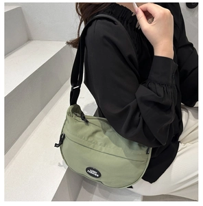 Dettaglio borsa a tracolla verde in tela con logo Lucky Fashion e tracolla regolabile