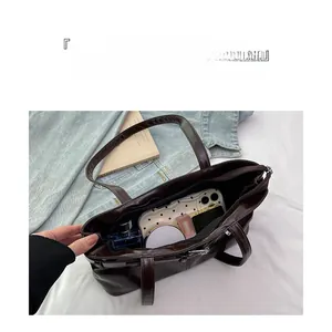 Detail view of large dark brown tote bag interior storage for phone and cosmetics