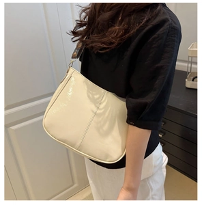 Detail of hobo bag in cream glossy finish with vintage ethnic style woven strap
