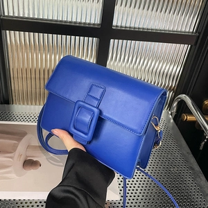 Bright blue rectangle crossbody bag with oversized buckle and adjustable leather strap