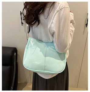 Detail of mint green patent leather tote with contrast vintage monogram shoulder strap