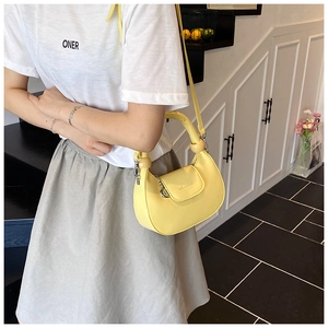 Detail of yellow crescent bag with wooden bead handle and metal chain decoration