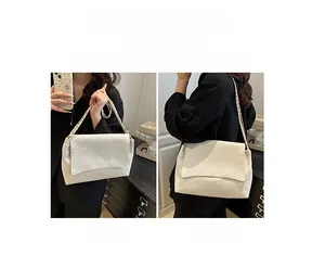Détail du sac à bandoulière tressé montrant les styles porté main et porté à l'épaule