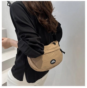 Dettaglio borsa a mezzaluna in nylon kaki con logo Lucky Fashion e texture a pieghe