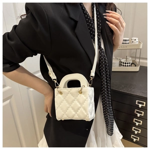 Close-up of white quilted mini handbag featuring fine stitching and gold metal hardware