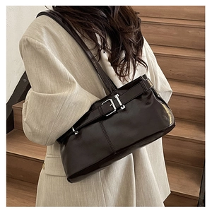 Detail view of the chocolate leather shoulder bag with a silver metal buckle and strap