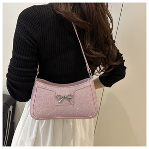 Detail der rosa Glitzer-Achseltasche mit silberner Schleife, von Model getragen