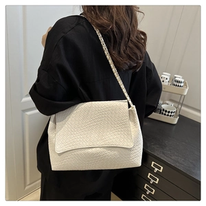 Gros plan sur un sac bandoulière blanc en cuir tressé avec chaîne en or et argent