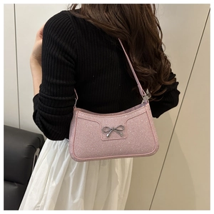 Gros plan du sac sous le bras rose pailleté avec nœud métallique sur un mannequin