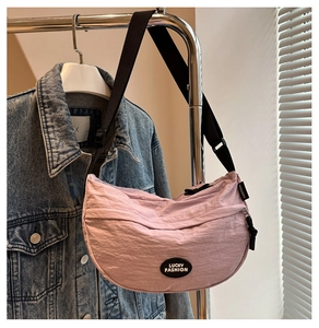 Close-up of light purple crescent bag with Lucky Fashion logo and pleated nylon texture