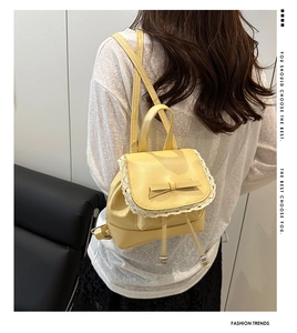 Détail du mini sac à dos jaune avec bordure en dentelle blanche et petit nœud