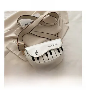 Détail du sac bandoulière blanc avec motif de touches de piano et texte I LOVE MUSIC
