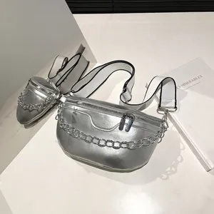 Sac de poitrine argenté métallique avec chaîne épaisse et large sangle tissée sur fond blanc
