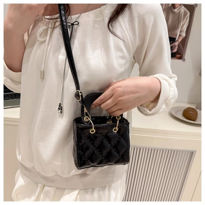 Détail du mini sac noir matelassé avec finition brillante et ferrures en métal doré