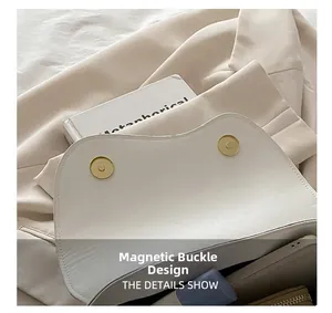 Gros plan du sac blanc avec doubles boucles magnétiques dorées et texture grainée