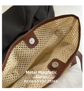 Detail of internal metal magnetic buckle on a straw tote bag with brown leather trim