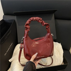 Chic burgundy crescent handbag with pleated cloud handle and shiny finish leather
