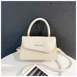 Detail of cream-colored crossbody bag featuring textured fabric and leather splicing