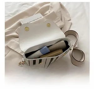 Vue intérieure d'un sac demi-lune blanc montrant l'espace pour téléphone et portefeuille