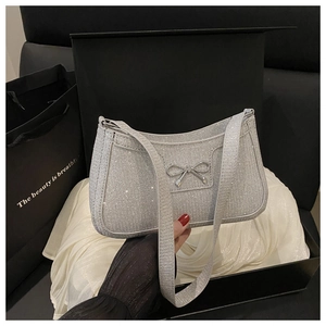 Detailed view of silver sequin shoulder bag with bow charm in premium black gift box