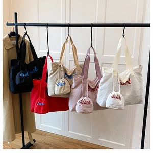 Detail of embroidered Beach canvas tote bags available in five colors with matching pouches