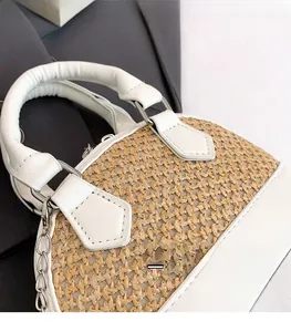 Close-up of woven straw and white leather shell bag with silver chain and round handle