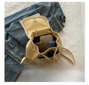 Détails de capacité du sac à dos en similicuir jaune avec dentelle montrant l'espace de rangement