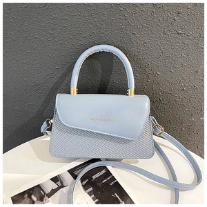 Detail of light blue textured leather handbag with gold Fashion & Bags lettering