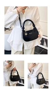 Detail of black semi-circle hobo bag featuring silver logo and detachable shoulder strap