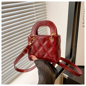 Détail du mini sac matelassé rouge en cuir brillant avec accessoires dorés