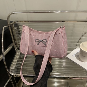 Sac à bandoulière rose à paillettes avec nœud en métal argenté et texture de luxe