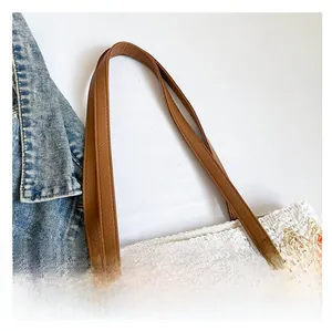 Close-up of wavy texture weaving and brown leather handle on a summer beach tote bag