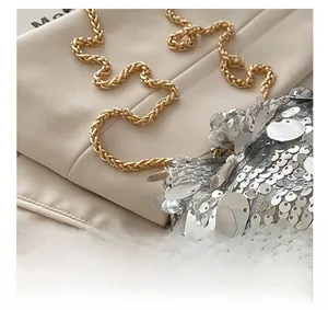 Detailed close-up of sparkling silver sequins and premium golden metal chain strap