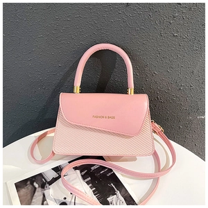 Detail of pink dual-use handbag with woven texture, metal hardware and top handle