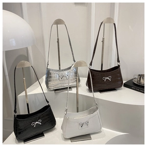 Detail of crocodile pattern faux leather shoulder bags with elegant metal bow buckle