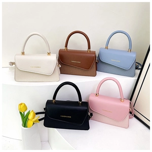 Collection of textured leather handbags in five colors with unique asymmetric flap design