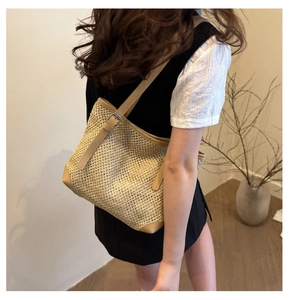 Detail of woven tote bag featuring honeycomb texture and adjustable leather strap