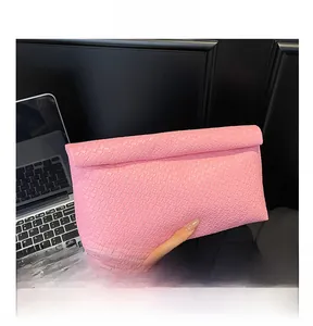 Detail showing the pink woven texture and envelope fold design of the women clutch bag