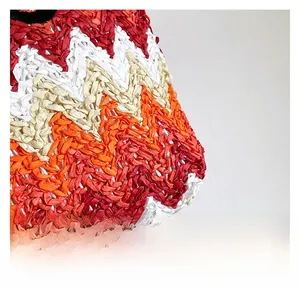 Detailed macro view of high-quality colorful zigzag weave texture on a straw beach bag