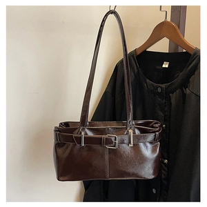Detail of vintage brown glossy leather shoulder bag with adjustable silver buckle