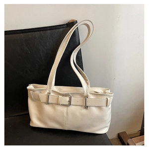 Close-up of creamy white PU leather shoulder bag with decorative buckle on a black chair